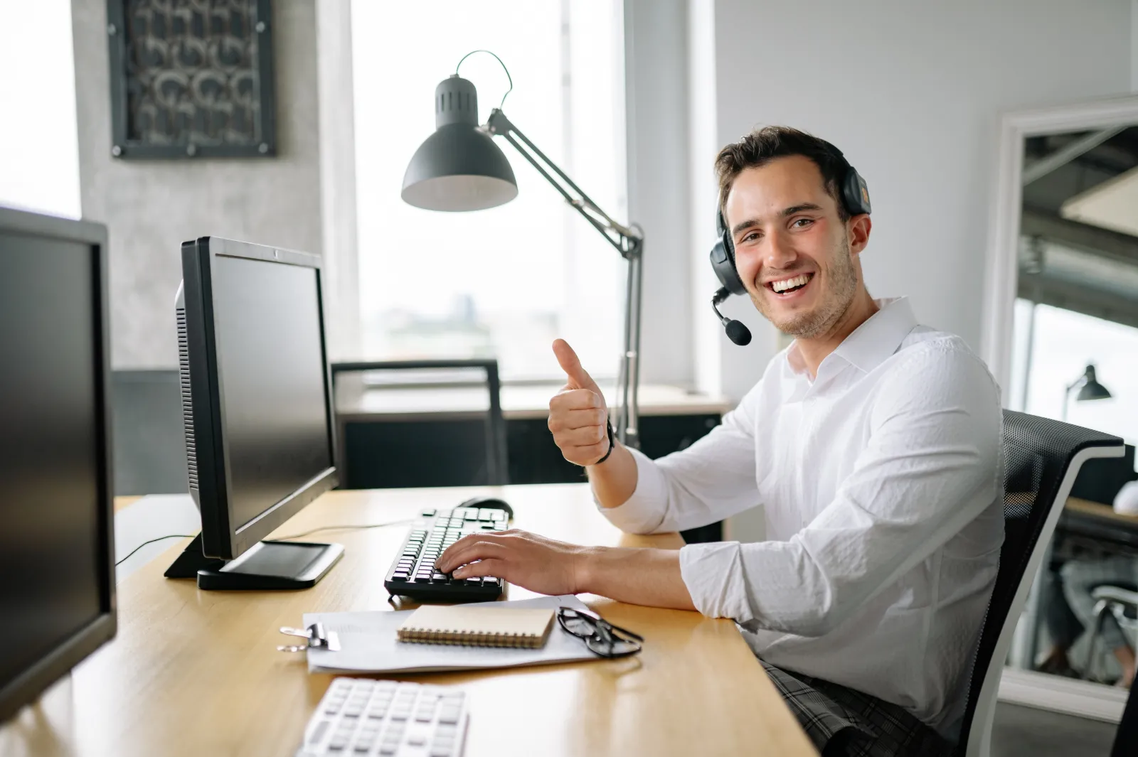 Professional male at his desk with a headset and computer