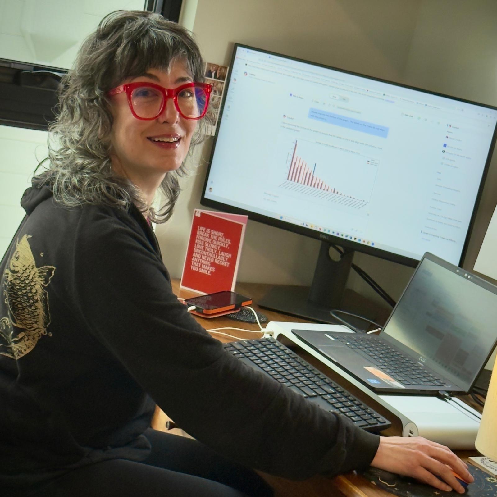 Image of Mariaelena sitting at her desk using Copilot