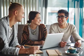 3 people collaberating at a desk