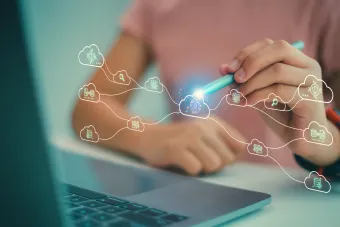 Women with cloud computing diagrams sitting at her desk with her laptop