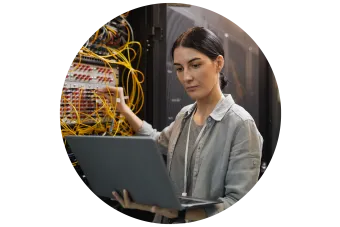 Female Network Technician Inspecting Servers in Data Center