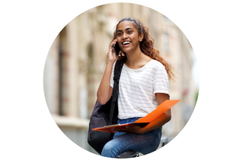 female sitting on hand rail outside while on the phone