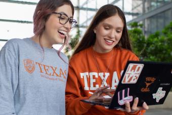 Two students around a laptop discovering 