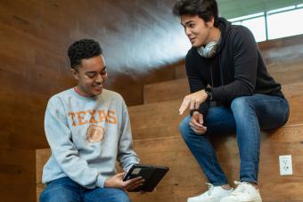 UT students conversating around an ipad