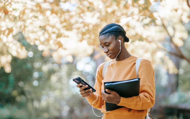 Student outside on phone checking email